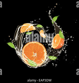 Arance fresche in acqua splash, isolati su sfondo nero Foto Stock