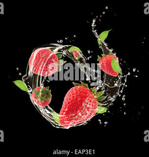 Fragole fresche in acqua splash, isolati su sfondo nero Foto Stock