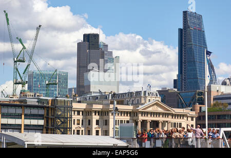 I turisti la visualizzazione di City of London skyline dal fiume Tamigi con il distintivo 'Cheesegrater' edificio sulla destra e Inghilterra Foto Stock