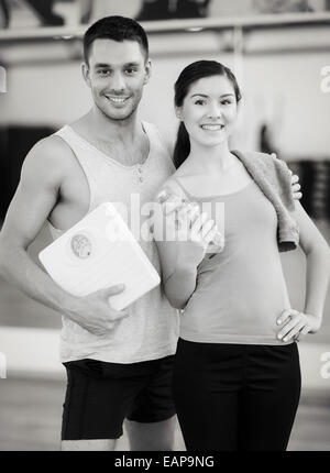 Due persone sorridenti con scala in palestra Foto Stock