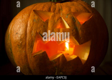 Zucca di Halloween con candela all'interno. Jack-o-lantern. Scolpite di zucca. Foto Stock