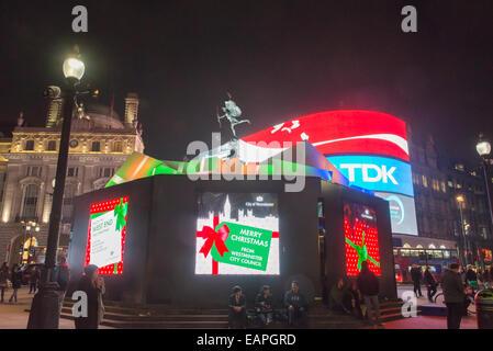 Piccadilly Circus, Londra, Regno Unito. Il 19 novembre 2014. La statua di Eros a Londra Piccadilly Circus è circondato con 'Regali di natale' e pannelli pubblicitari. Credito: Matteo Chattle/Alamy Live News Foto Stock