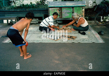 Un ragazzo orologi uomini giocare a scacchi in strada a Yogyakarta in Java in Indonesia nel sud-est asiatico in Estremo Oriente. Reportage di Viaggio Fotogiornalismo Foto Stock