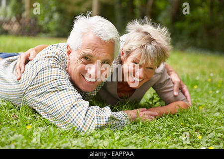 Felice coppia senior posa su un prato in estate Foto Stock