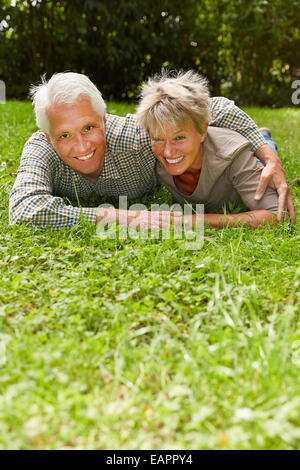 Felice coppia senior in amore la posa su un prato in estate Foto Stock