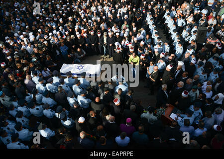 Gerusalemme, Yanuh-Jat. Xix Nov, 2014. Persone in lutto si riuniscono attorno alla bandiera-coperto bara di drusi israeliani funzionario di polizia Zidan Seif, membro di Israele la minoranza drusi, durante il suo funerale nel suo nord home villaggio di Yanuh-Jat, su nov. 19, 2014. Saief morì dopo aver subito gravi lesioni, portando il numero di morti per cinque, quando due palestinesi armati con una pistola e un coltello da prosciutto irrompono nella sinagoga e ucciso quattro Israeliani prima di essere ucciso a Gerusalemme il più sanguinoso attentato in anni. Credito: JINI/Gil Eliyahu/Xinhua/Alamy Live News Foto Stock