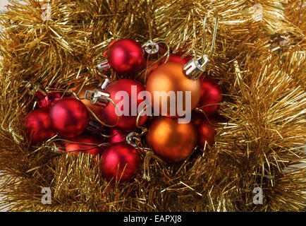 Rosso brillante e arancio palle di Natale e lucido tinsel Foto Stock