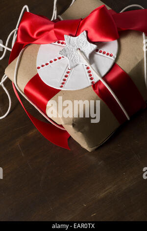 Confezione regalo, artigianato carta con nastro marrone e etichetta circolare con stella Foto Stock