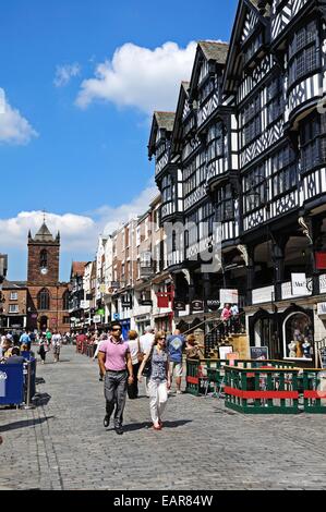 Edifici e negozi lungo Bridge Street con la chiesa di St Peters alla parte posteriore di Chester, Cheshire, Inghilterra, Regno Unito, Europa occidentale. Foto Stock