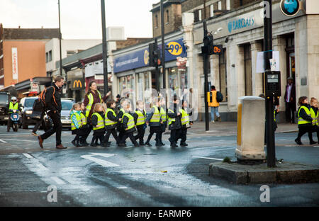 Gli scolari di attraversamento del gruppo a Balham / Tooting London - REGNO UNITO Foto Stock