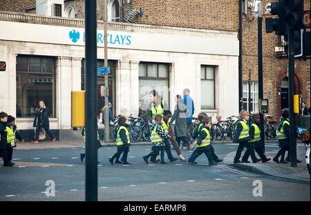 Gli scolari di attraversamento del gruppo a Balham / Tooting London - REGNO UNITO Foto Stock