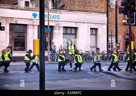 Gli scolari di attraversamento del gruppo a Balham / Tooting London - REGNO UNITO Foto Stock