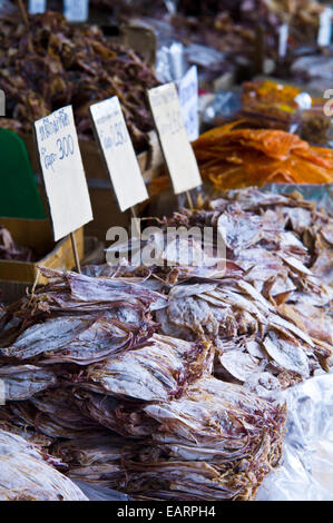 Pile di calamaro asciugato e frutti di mare in vendita in un mercato all'aperto. Foto Stock