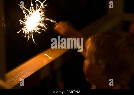 Un bambino gioca con un partito sparkler a New Years Eve notte. Foto Stock