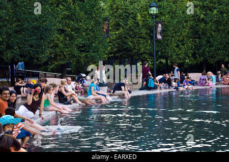 I turisti raffreddare i loro piedi in una piscina con fontana del Memorial Day. Foto Stock