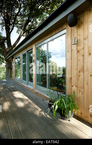 Bungalow in legno con terrazza nella zona boschiva, Midlothian, Scotland, Regno Unito Foto Stock