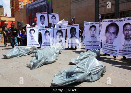 La Paz in Bolivia. Xx Novembre, 2014. Manifestanti giacciono a terra in sacchetti di plastica che rappresentano body bags durante una manifestazione di protesta per chiedere giustizia per i 43 studenti mancanti in Messico e di protesta contro il governo messicano per la gestione del caso e la corruzione. La giornata di oggi è stata designata una giornata di azione globale per Ayotzinapa; uno sciopero nazionale è prevista in Messico e molti si stanno svolgendo le proteste in tutto il mondo per mostrare il loro sostegno. Gli studenti sono scomparsi dopo scontri con la polizia la notte del 26 settembre nella città di Iguala. Credito: James Brunker / Alamy Live News Foto Stock