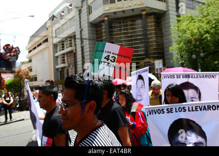 La Paz in Bolivia. Xx Novembre, 2014. Un manifestante indossa una bandiera messicana con 43 Ayotzinapa su di esso durante il mese di marzo a chiedere giustizia per i 43 studenti mancanti in Messico e di protesta contro il governo messicano per la gestione del caso e la corruzione. La giornata di oggi è stata designata una giornata di azione globale per Ayotzinapa; uno sciopero nazionale è prevista in Messico e molti si stanno svolgendo le proteste in tutto il mondo per mostrare il loro sostegno. Gli studenti (che erano da una scuola di formazione per insegnanti) è scomparso dopo scontri con la polizia la notte del 26 settembre nella città di Iguala. Credito: James Brunker / Alamy Live Foto Stock