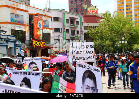 La Paz, Bolivia. 20 Novembre 2014. I manifestanti marciano per chiedere giustizia per i 43 studenti scomparsi in Messico e protestano contro la gestione del caso da parte del governo messicano e la corruzione. Un cartello accusa il governo messicano di essere uno stato narco. Oggi è stata designata una Giornata d'azione globale per Ayotzinapa; in Messico è previsto uno sciopero nazionale e molte proteste si svolgono in tutto il mondo. Gli studenti (che erano di un collegio di formazione degli insegnanti) sono scomparsi dopo aver scontrato con la polizia la notte del 26 settembre nella città di Iguala. Credit: James Brunker / Alamy Live News Foto Stock