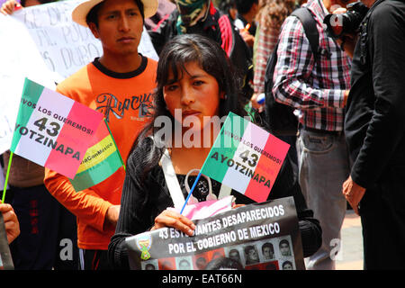 La Paz in Bolivia. Xx Novembre, 2014. Un manifestante detiene una bandiera messicana con 43 Ayotzinapa su di esso durante il mese di marzo a chiedere giustizia per i 43 studenti mancanti in Messico e di protesta contro il governo messicano per la gestione del caso e la corruzione. La giornata di oggi è stata designata una giornata di azione globale per Ayotzinapa; uno sciopero nazionale è prevista in Messico e molti si stanno svolgendo le proteste in tutto il mondo per mostrare il loro sostegno. Gli studenti (che erano da una scuola di formazione per insegnanti) è scomparso dopo scontri con la polizia la notte del 26 settembre nella città di Iguala. Credito: James Brunker / Alamy Live Foto Stock