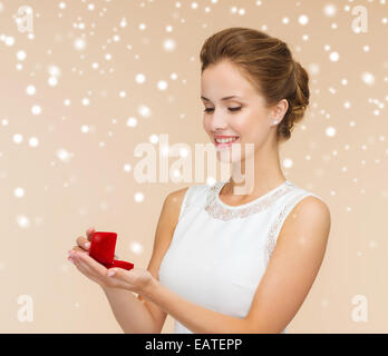 Donna sorridente azienda confezione regalo rossa con anello Foto Stock