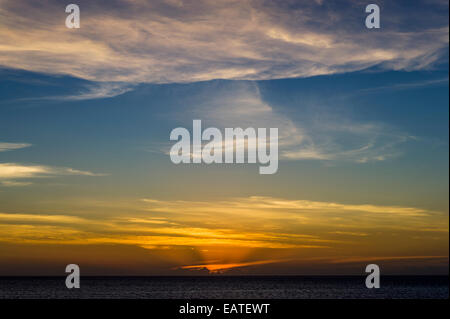 Post-incandescenza al tramonto e nuvole pastello su una calma oceano tropicale. Foto Stock