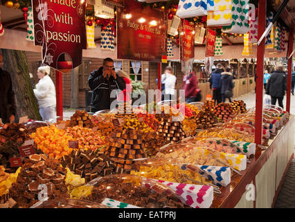 I rivenditori di dolciumi scelgono e mescolano dolciumi per le feste, cioccolato e dolci. Un'affollata selezione di dolciumi. Fai un mix di barattoli dolci e fudge store, parte del mercatino di Natale di Liverpool a St George's Place, Liverpool, Regno Unito Foto Stock