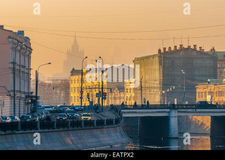 Sun a Mosca, in Russia. Giovedì 9 Novembre 20, 2014. Meteo: Sun, lo smog e il gelo a Mosca, in Russia. La temperatura è piuttosto freddo, fino a -11°C (12,2°F). O nuvoloso o soleggiato, nessuna neve a tutti e praticamente nessun vento. Così le regole di smog il giorno e trasporti aggiunge i suoi gas di scarico per l'aria di città al di sopra di tutto il resto. Vista del canale di bypass sul fiume di Mosca. Il grattacielo del Ministero degli Affari esteri della Russia è difficilmente visibile, e sottili ombre dei grattacieli della nuova città di Mosca alla destra del ministero edificio. Credito: Alex Immagini/Alamy Live News Foto Stock