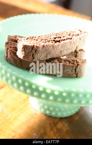 Biscotti al cioccolato in una vendemmia verde milkglass piatto su una tavola di legno Foto Stock