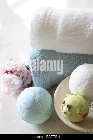 Round decorativi saponi di bianco e blu con asciugamani e un pennello ancora in vita con un fiore di peonie Foto Stock