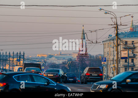 Sun a Mosca, in Russia. Giovedì 9 Novembre 20, 2014. Meteo: Sun, lo smog e il gelo a Mosca, in Russia. La temperatura è piuttosto freddo, fino a -11°C (12,2°F). O nuvoloso o soleggiato, nessuna neve a tutti e praticamente nessun vento. Così le regole di smog il giorno e trasporti aggiunge i suoi gas di scarico per l'aria di città al di sopra di tutto il resto. Traffico oltre il grande ponte di pietra sul fiume di Mosca. Borovitskaya torre (rabboccato con ruby star) e la stella di torre Vodovzvodnaya (estrema destra). Credito: Alex Immagini/Alamy Live News Foto Stock