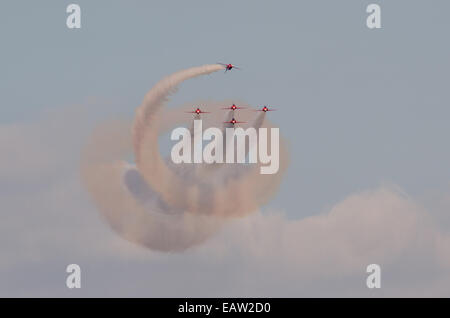 Cinque RAF frecce rosse eseguire un acrobatico manovra di rotolamento in formazione con il bianco e il fumo al 2014 Airshow di Southport Foto Stock