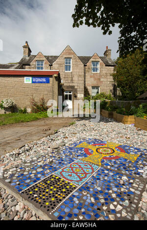 La scuola primaria sull'Isola di iona di Mull, Scozia, con una croce di mosaici raffiguranti la famosa croce di Iona. Foto Stock