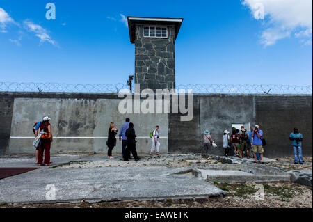 I turisti di esplorare una prigione di cantiere in una gita di Robben Island. Foto Stock