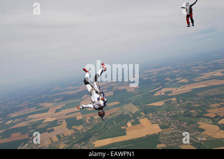 Freefly skydivers sono su una spettacolare terra e campi scenario nel cielo con 130 km/h. Foto Stock