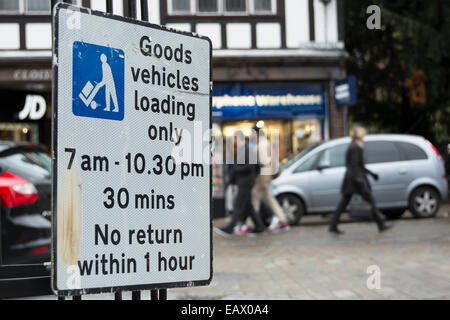 British cartello stradale che indica il parcheggio solo per i veicoli merci lo scarico durante i tempi indicati Foto Stock