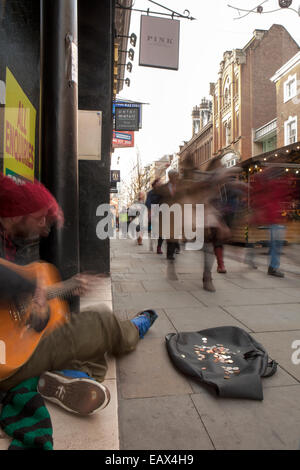 I soldi raccolti o donati al musicista di strada  Mercatini di Natale e dello shopping, Manchester, Regno Unito Foto Stock