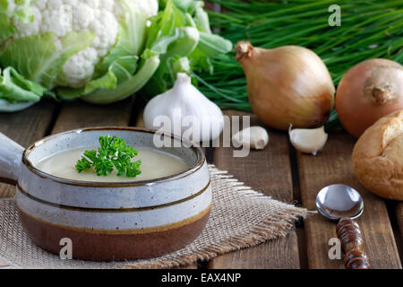 In casa zuppa di cavolfiore, cipolle, aglio, prezzemolo e erba cipollina e servite con pane Foto Stock