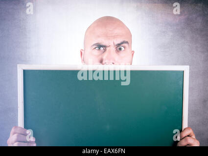 Bold man holding blank chalk board nelle sue mani Foto Stock