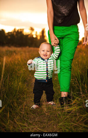 Adorable baby a camminare con la madre Foto Stock