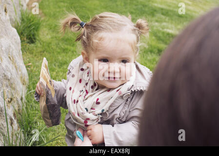 Baby girl all'aperto, borsa di snack a portata di mano Foto Stock