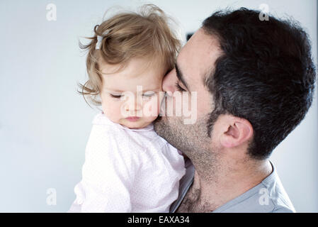 Padre kissing Baby girl sua guancia Foto Stock