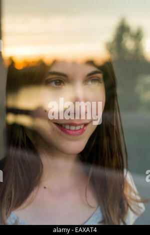 La donna guarda la regolazione del sole Foto Stock