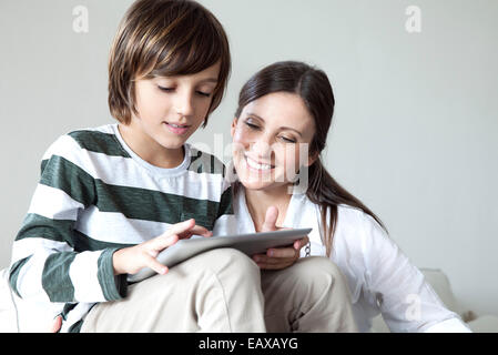 Madre e figlio utilizzando tavoletta digitale insieme Foto Stock