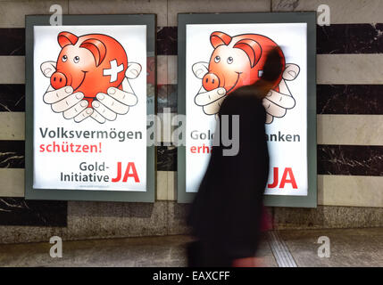 Zurigo, Svizzera. Xxi Nov, 2014. Persone alla stazione principale di Zurigo sono passando dalla campagna referendaria dei poster di Swiss 'Gold iniziativa' referendum che si terrà il Nov 30, 2014. Con una settimana a visitare la campagna referendaria del Swiss 'Gold iniziativa' sta andando a piena potenza in tutta la Svizzera. Il controverso referendum è volto a forzare la Banca Nazionale Svizzera per tenere almeno il 20% di tutti i beni in oro fisico. Credito: Erik Tham/Alamy Live News Foto Stock