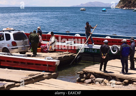 Traghetto caricato essendo spinto lontano dalla riva del lago Titicaca attraverso lo stretto di Tiquina in Bolivia Foto Stock