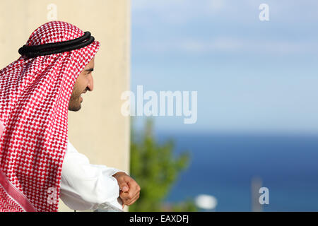 Felice rilassata arab arabia uomo che guarda il mare da un balcone di un hotel Foto Stock