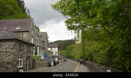 Holyhead Road, la strada principale del villaggio gallese di Betws-y-Coed, foderato con vecchi edifici in pietra e i boschi di smeraldo Foto Stock