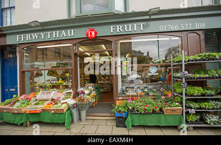 Negozio di frutta a Criccieth, Galles con segni sia in inglese e gallese, scatole di frutta in vendita sul sentiero e di stallo all'interno del cliente Foto Stock