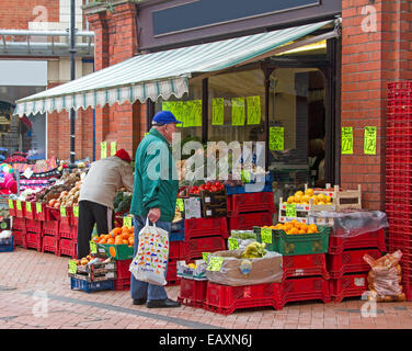 Uomo anziano con shopping bag guardando la frutta fresca e verdura in vendita al di fuori fruttivendolo shop a Wrexham in Galles Foto Stock